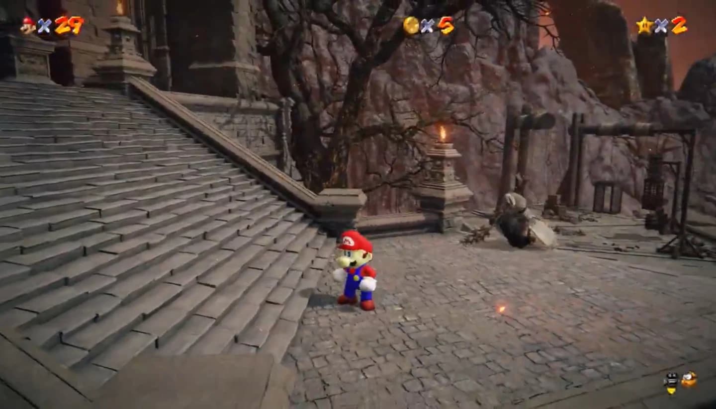 Mario aus Super Mario 64 steht neben einer Steintreppe in Elden Rings Vulkanfestung. Oben stehen seine Leben, Münzen und Sterne.